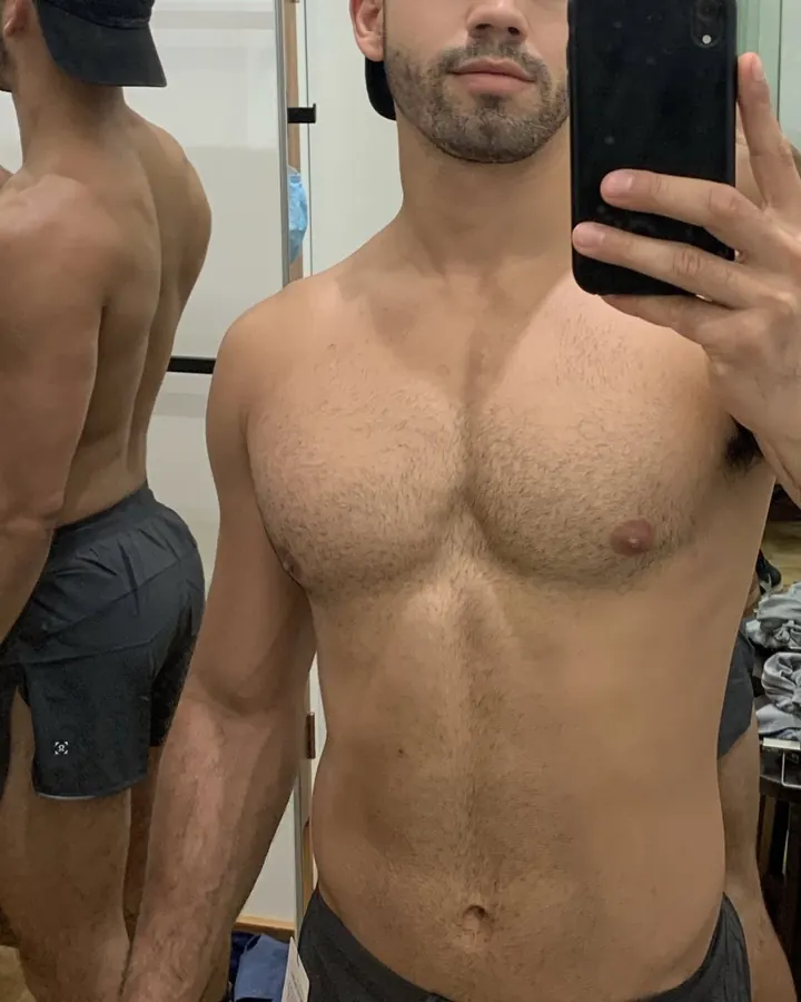 Homme européen torse nu, prenant un selfie devant un miroir, regard neutre, en sous-vêtements noirs